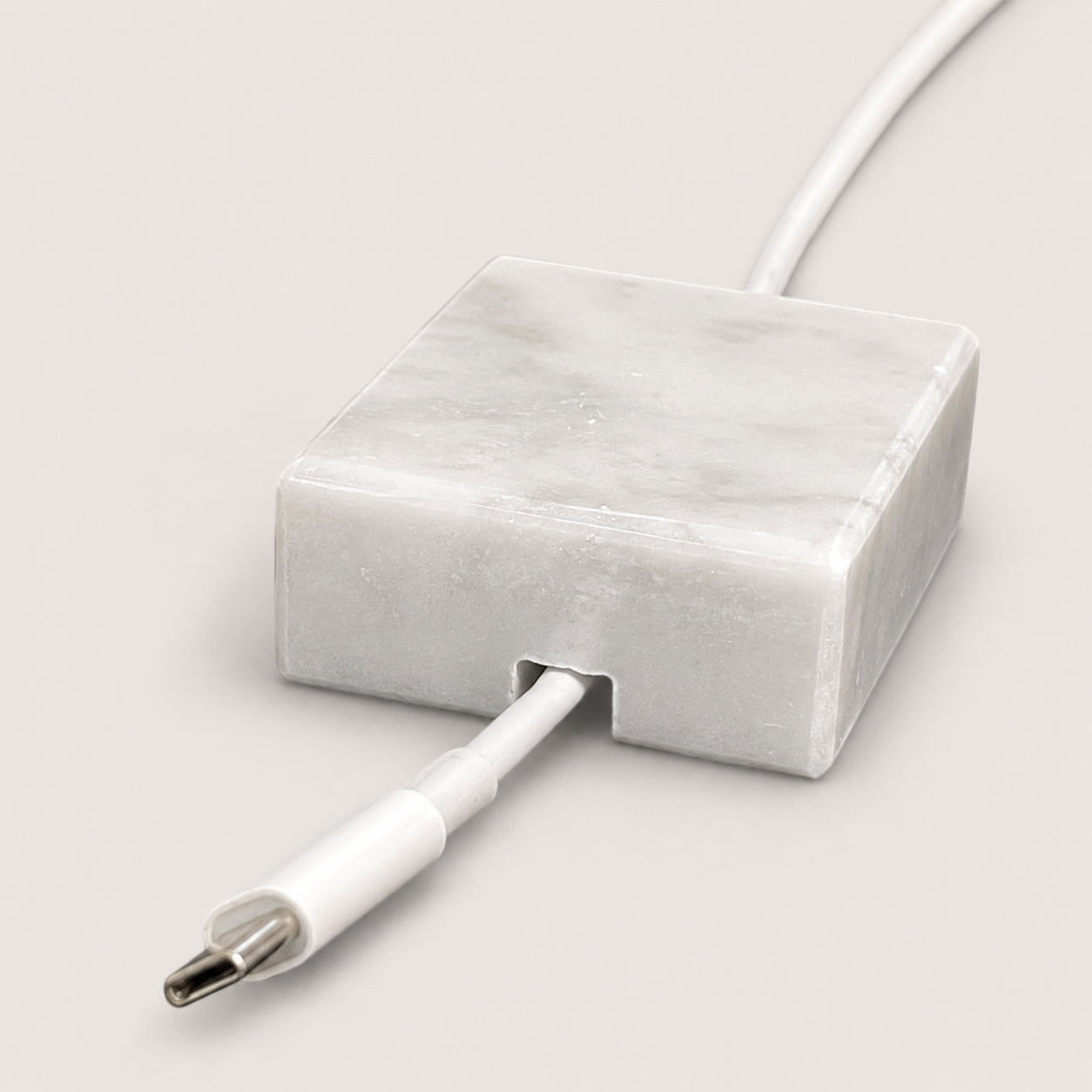 White Carrara Marble cord organizer with polished finish, single-cable slot