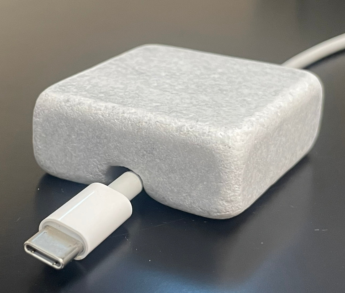 White Carrara Marble cord organizer with tumbled finish, single-cable slot