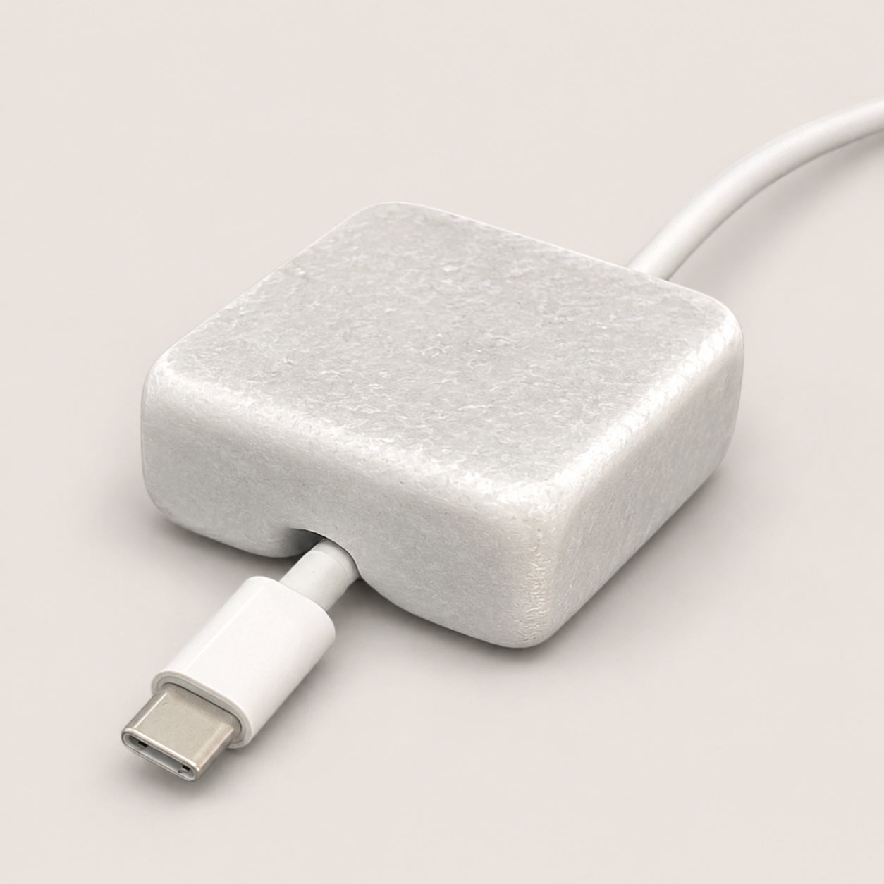White Carrara Marble cord organizer with tumbled finish, single-cable slot